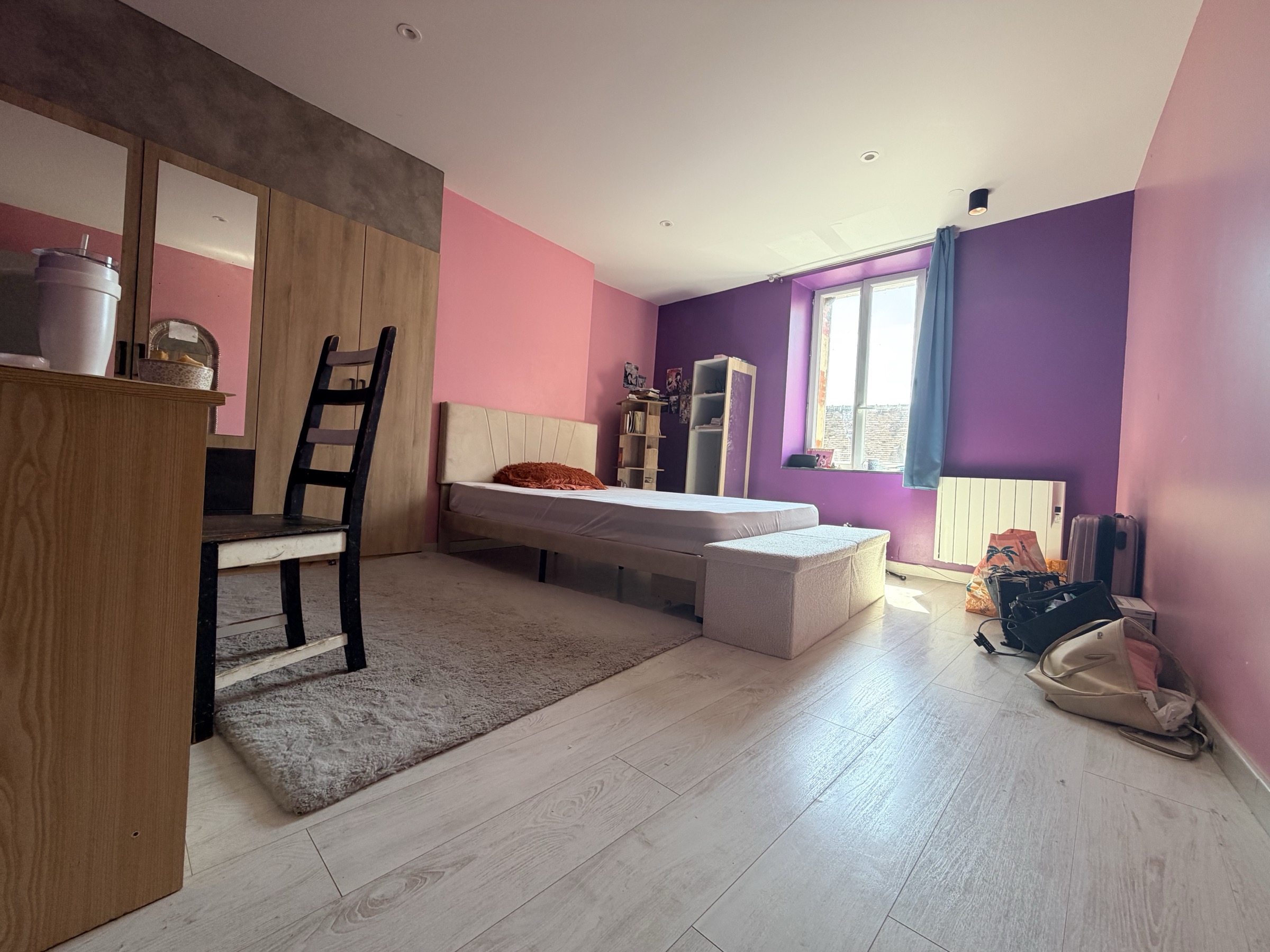 Chambre rénovée, murs peints, sol stratifié clair et mobilier moderne