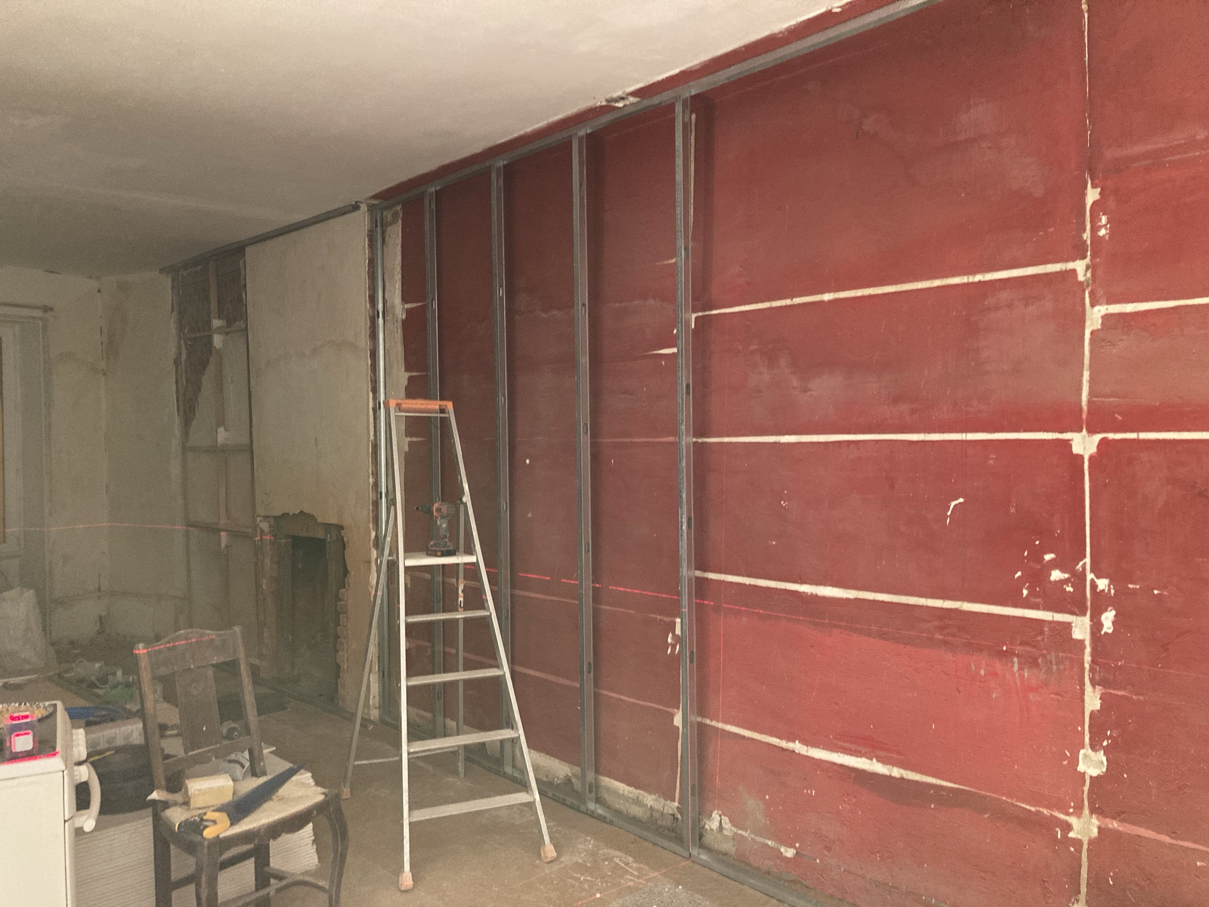 Salle à manger en chantier, ossature métallique et laser de niveau
