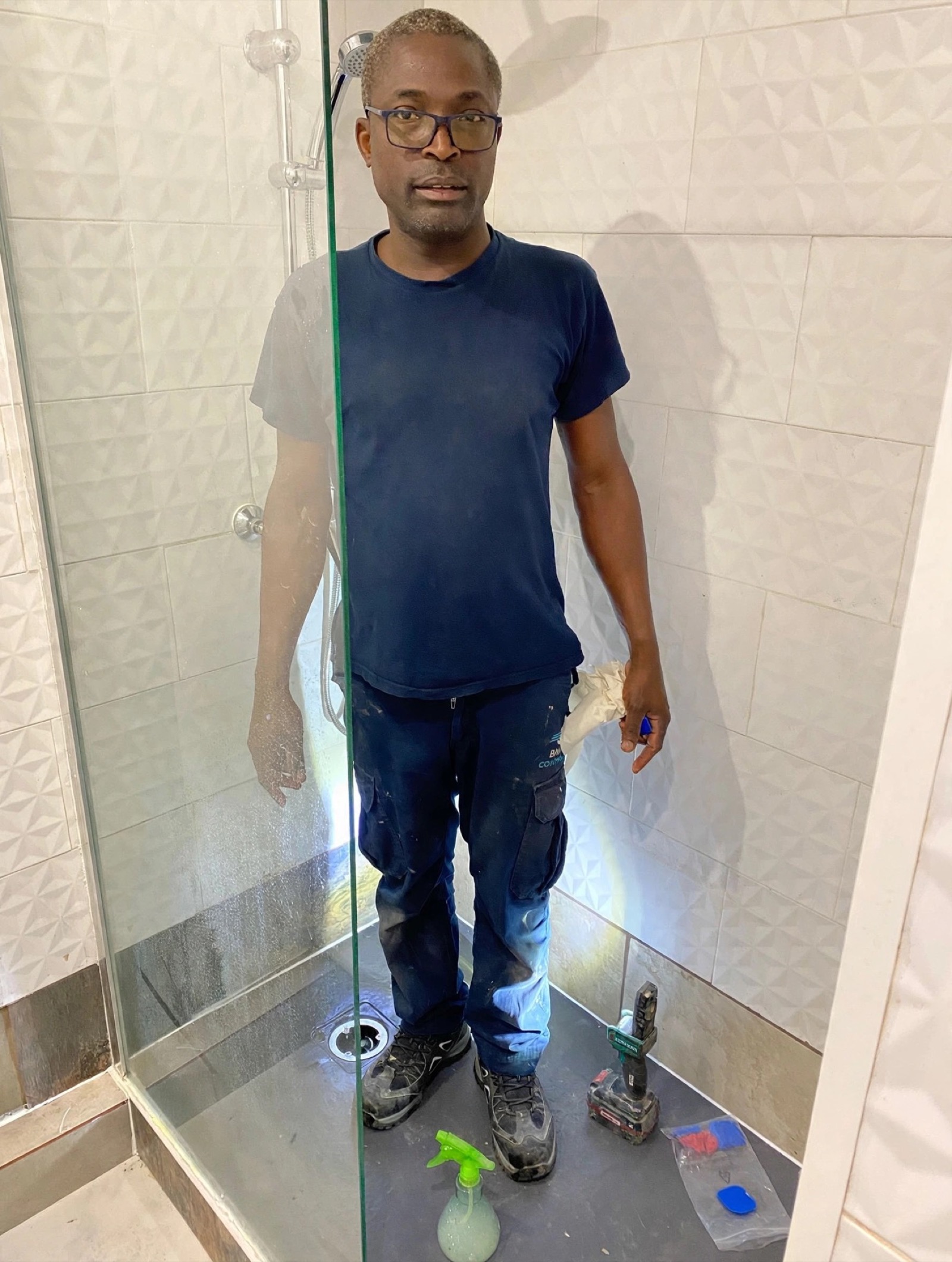 Christian Niangouna sur un chantier terminé, douche à l'italienne carrelée